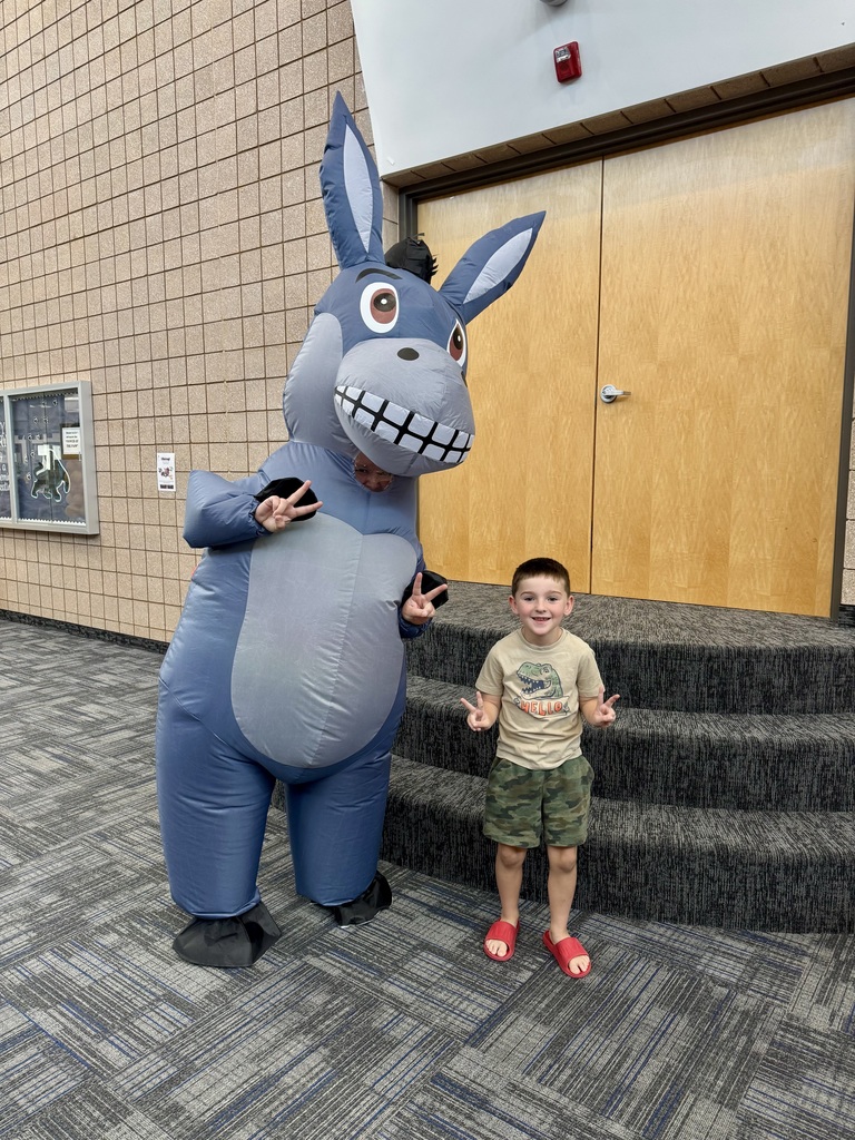 student doing peace sign with miss G in a donkey suit