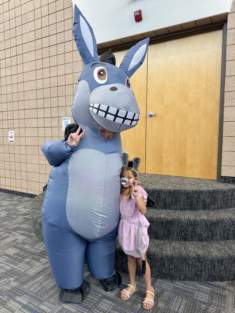 student in a donkey costume smiling with Miss G in a donkey costume