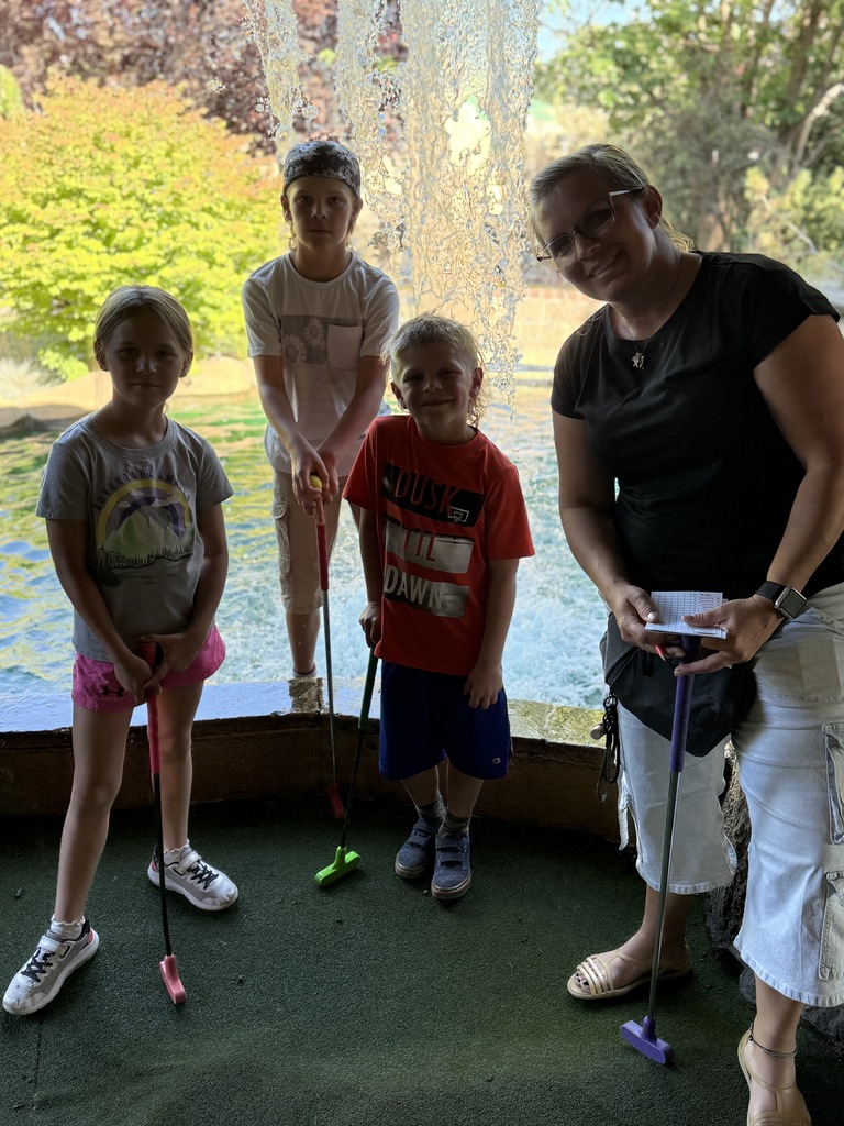 Mrs. Gines and kids playing mini golf