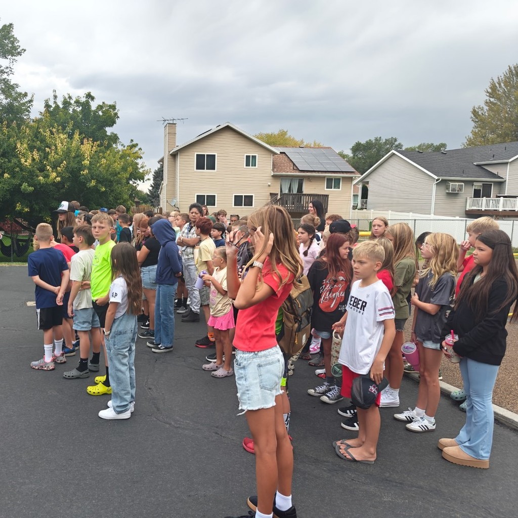 5th grade students listening on the playground