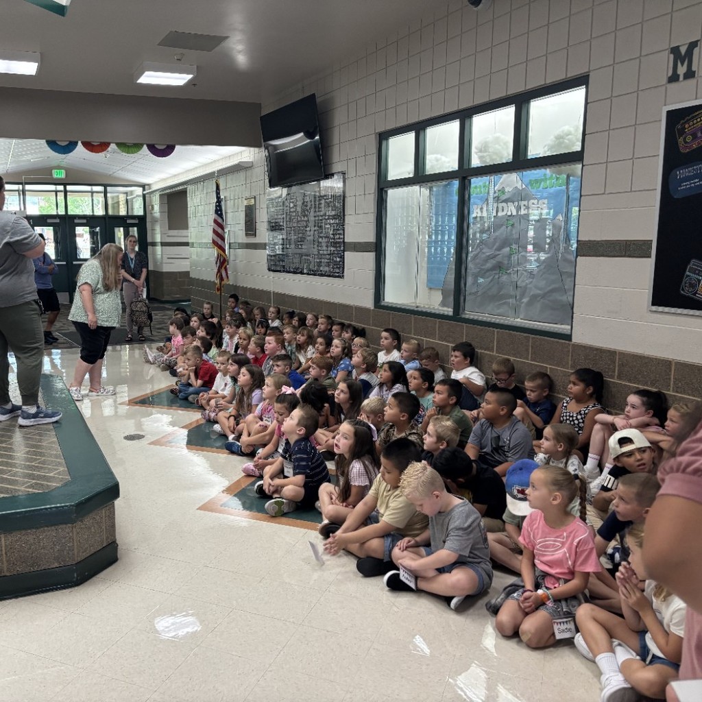 1st graders listening to bathroom procedures in school hallway