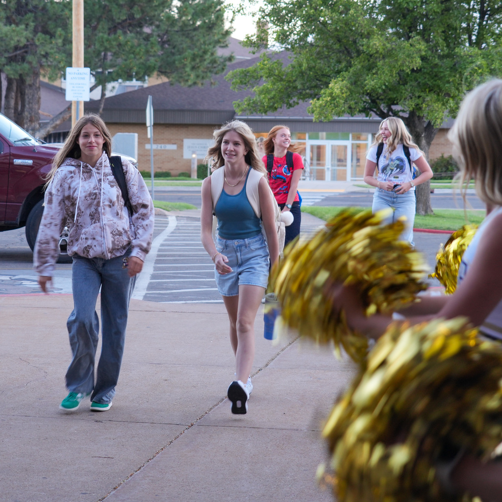 High School students walking up with cheerleaders cheering them on