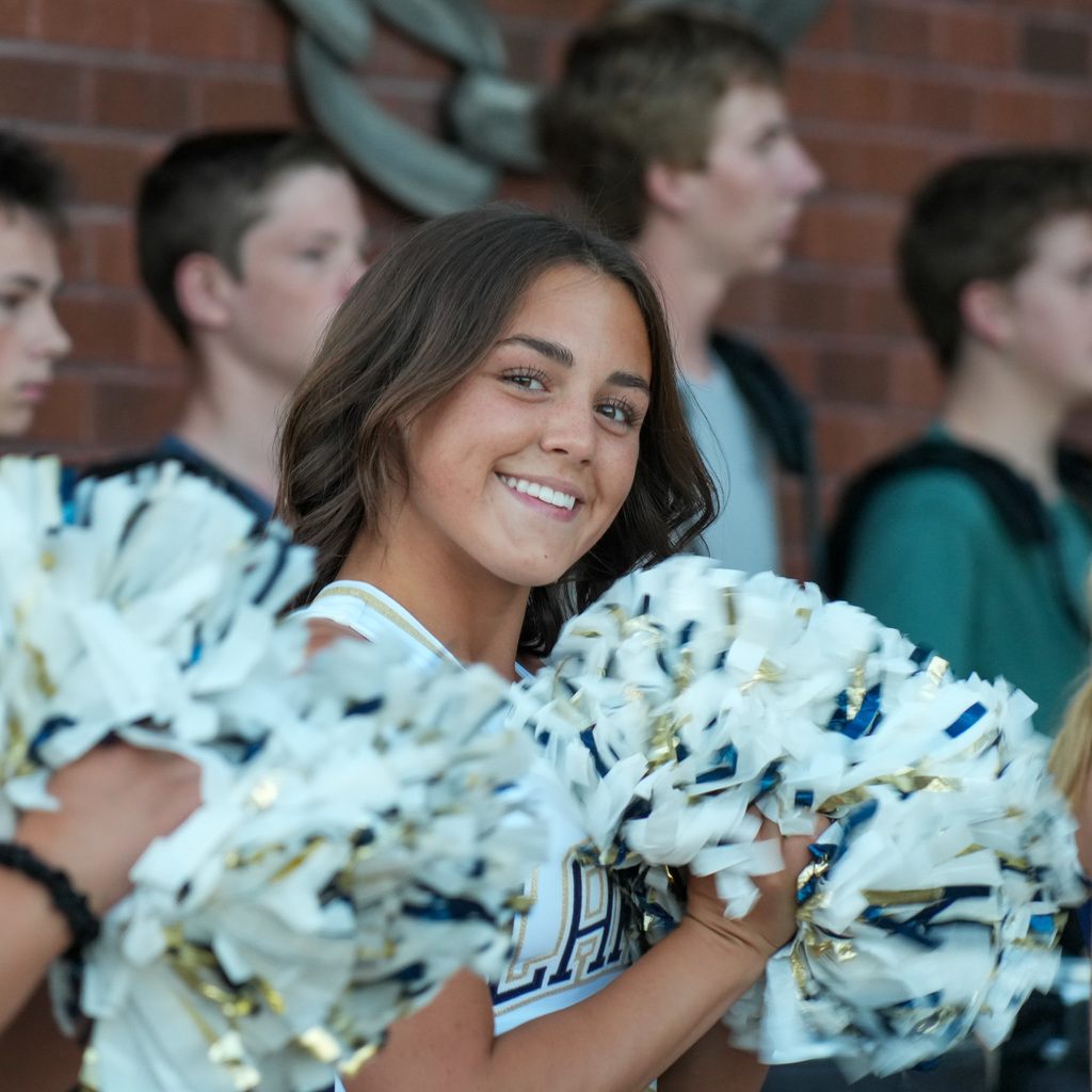 Cheerleader smiling with pom poms
