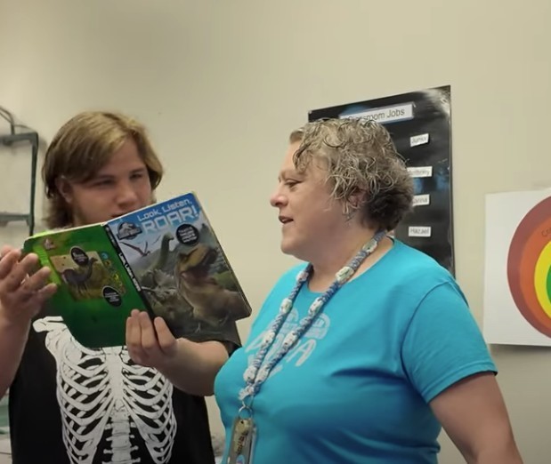 Nancy reading with a student.