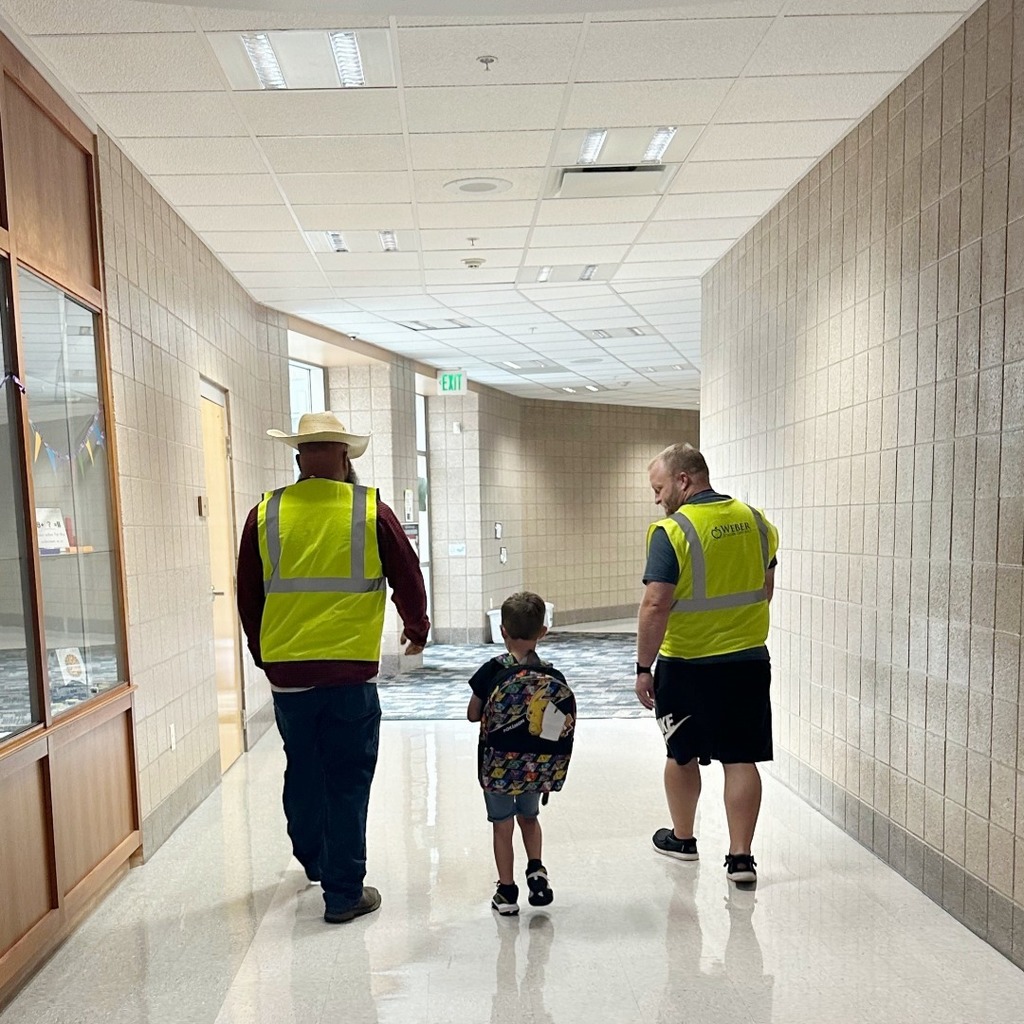 Two dads walking a student to class.