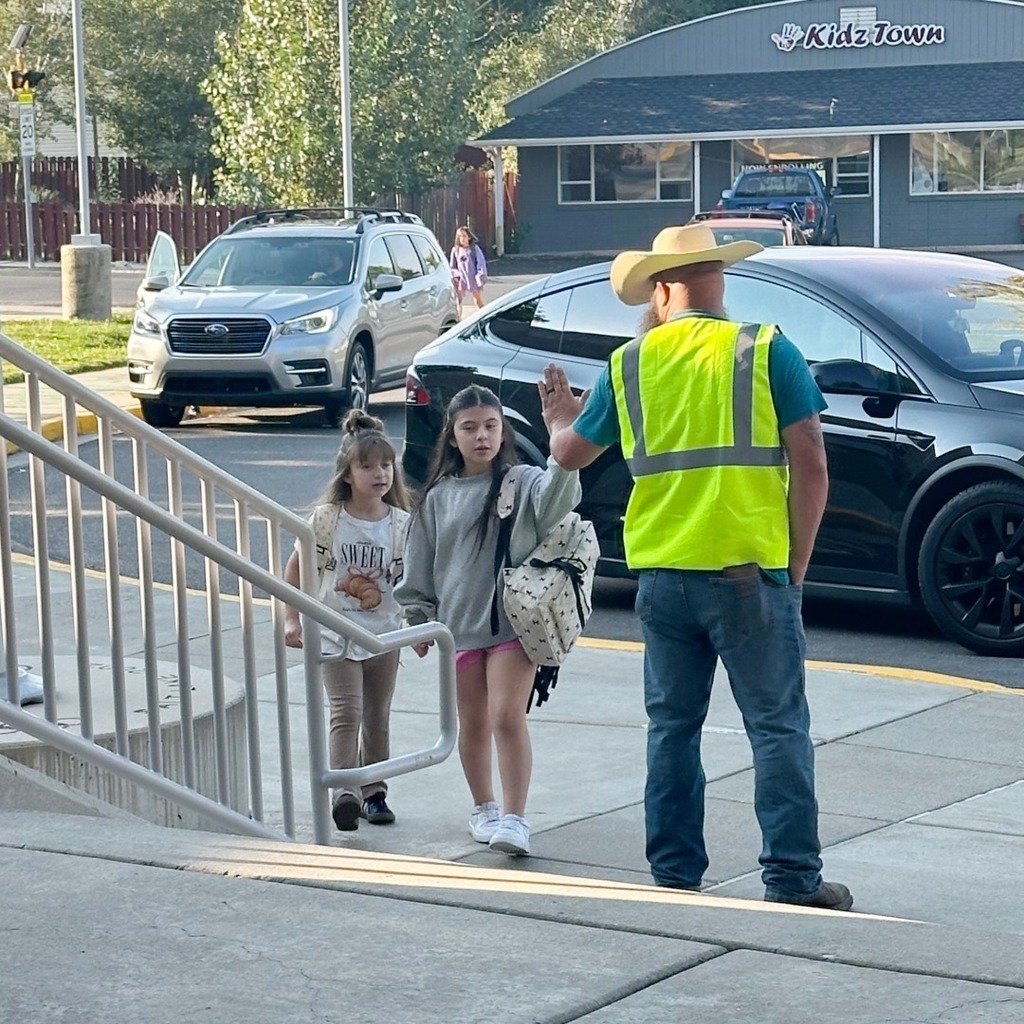 Rad dad give a high five to students.