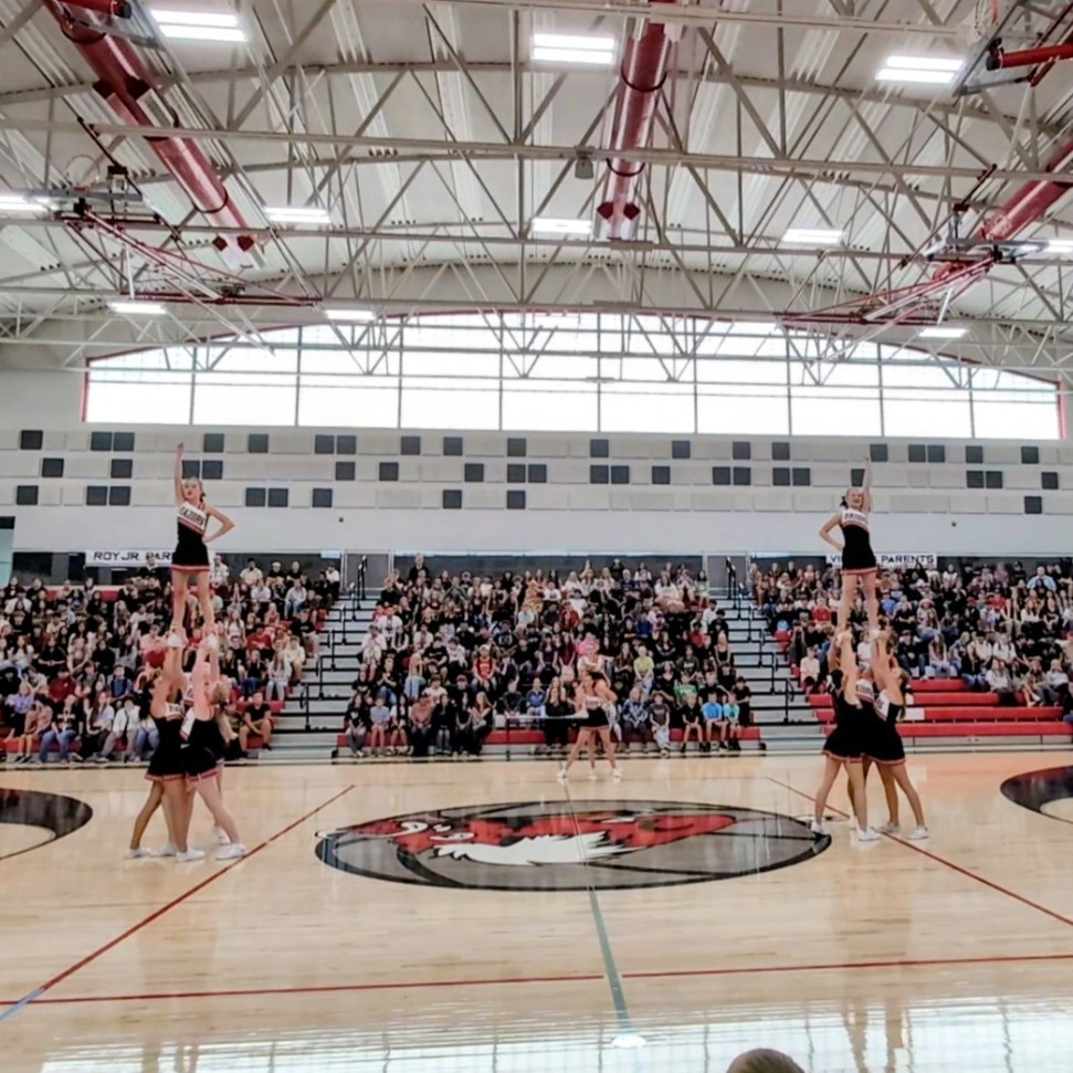 photo of opening assembly at Roy jr high, cheerleaders perform a stunt
