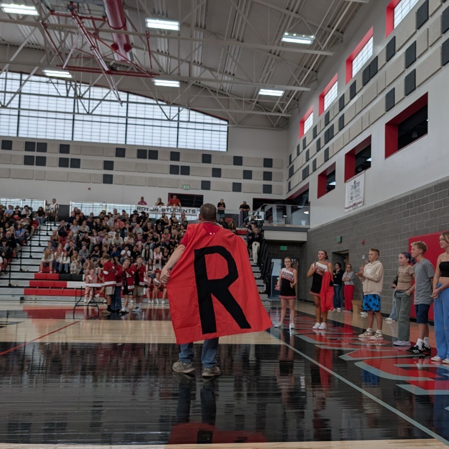 photo of opening assembly at Roy jr high, teacher wearing a hero cape