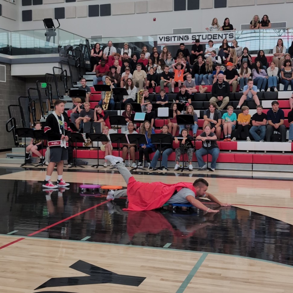 photo of opening assembly at Roy jr high, staff completing in the relay race