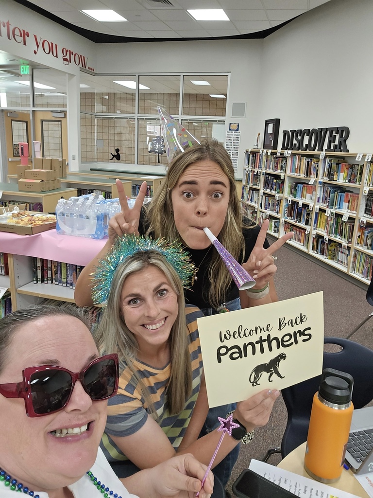 special education and speech therapist teachers making silly faces, wearing glasses, and smiling holding a sign that says "welcome back panthers"