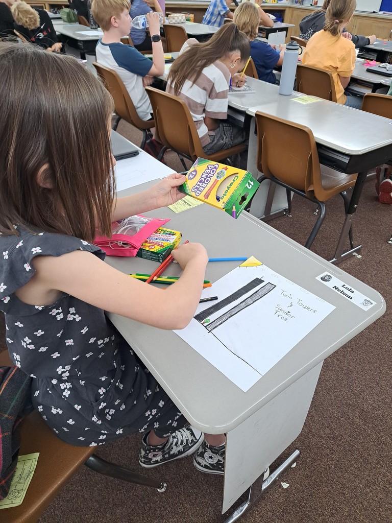 Young female student drawing a picture of the twin towers that are black and gray.