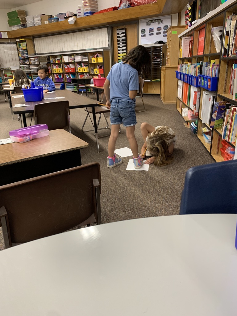 Helping to trace the size of their feet. 