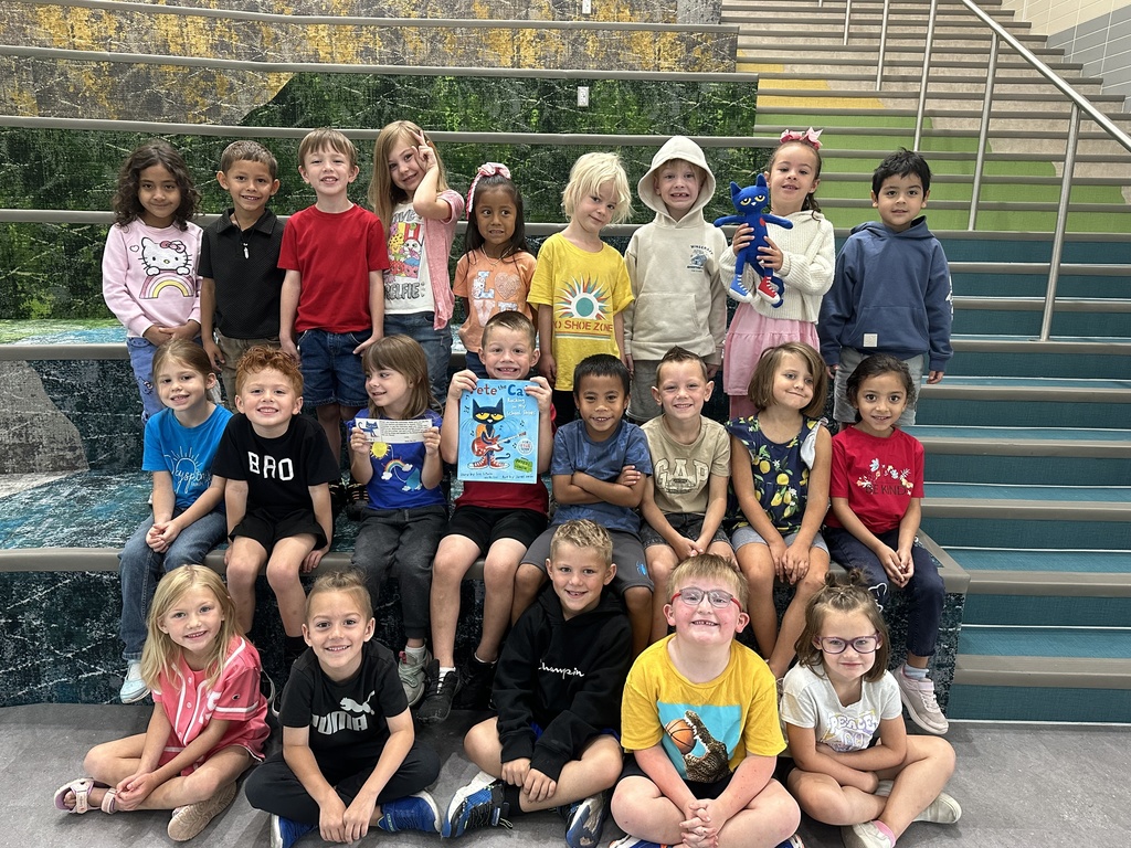 kindergarten students sitting on the the stairs with the pete the cat book and stuffed animal
