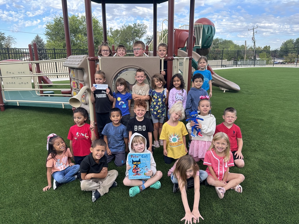 kindergarten students on the playground with pete the cat book and stuffed animal 