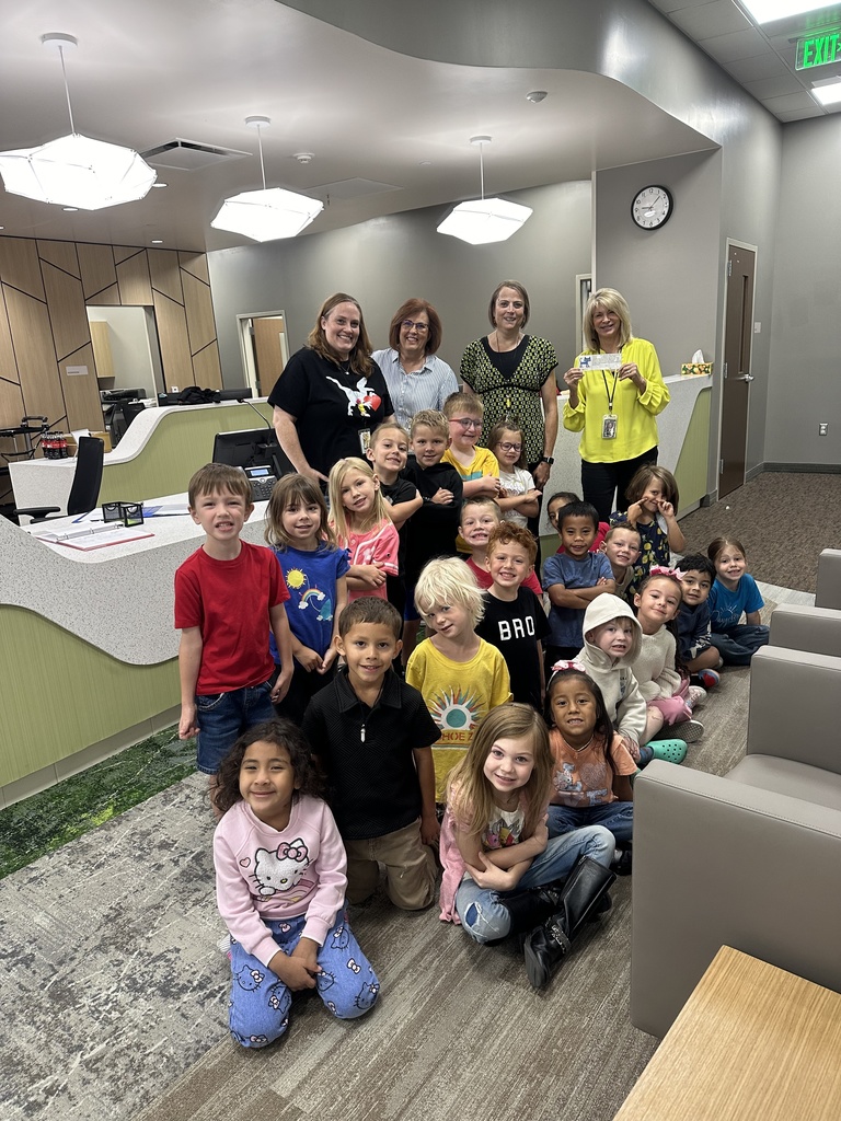 students standing in the office with office staff and Pete the Cat Stuffed animal