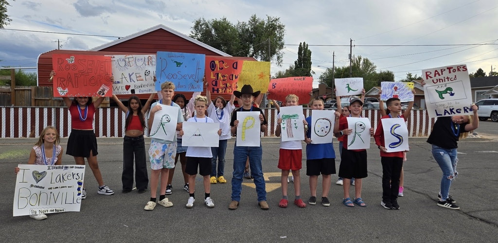 students holding handmade signs that say Raptors