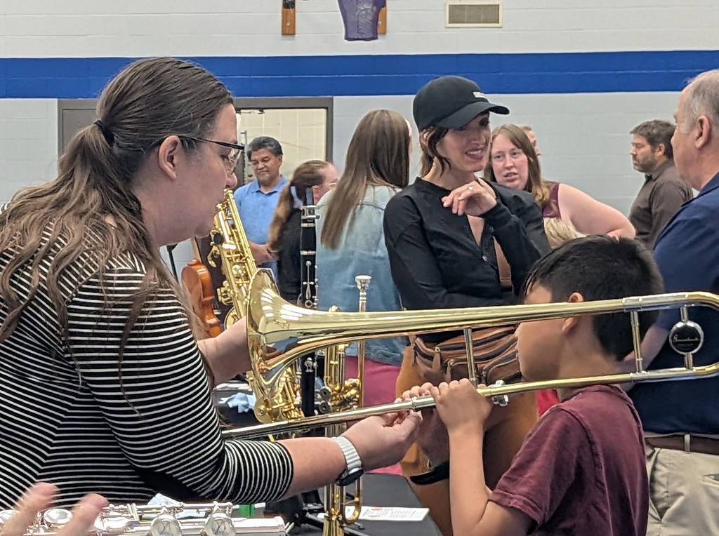 music teacher helping with a boy playing an instrument