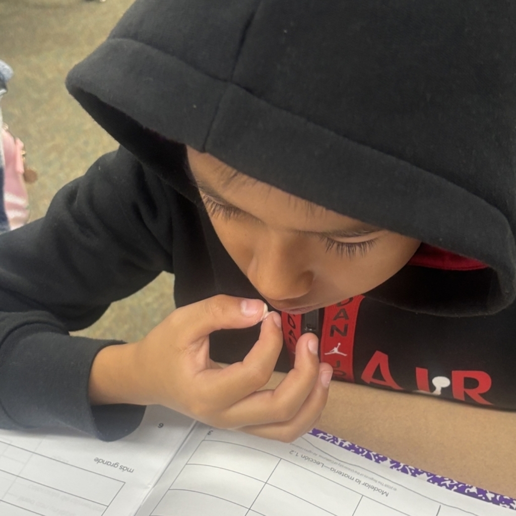 student working on science notebook while investigating substances