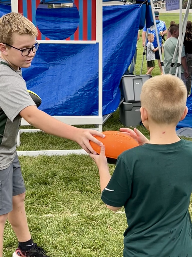 Student handing another student a ball to throw