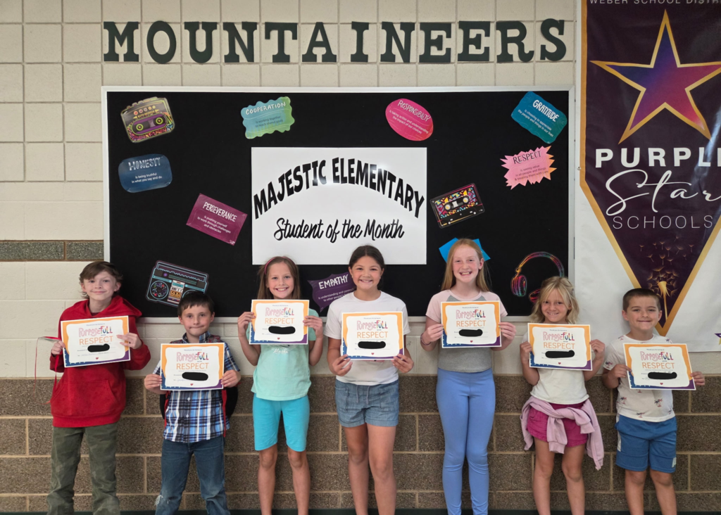 students holding certificates for student of the Month