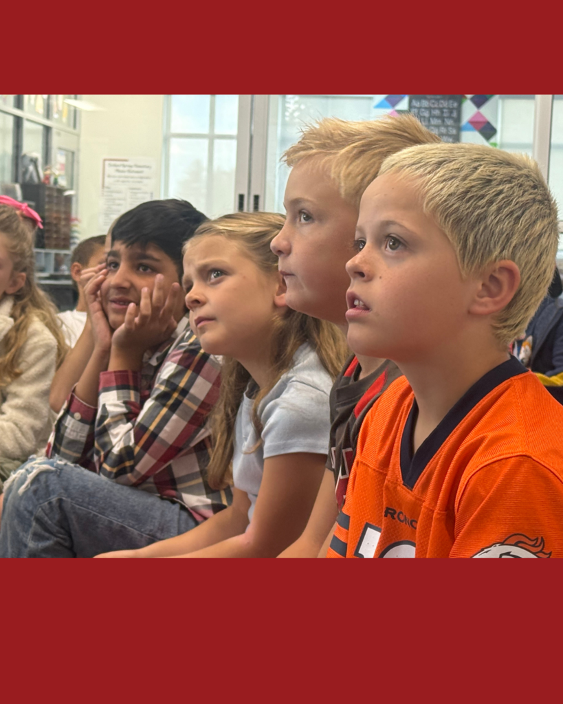 Group of students listening to the story that district leaders are reading. 