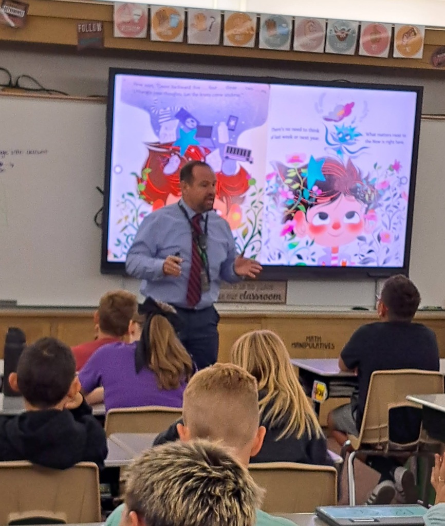 "Educators presenting to elementary school students in various classroom settings, with some using interactive displays."