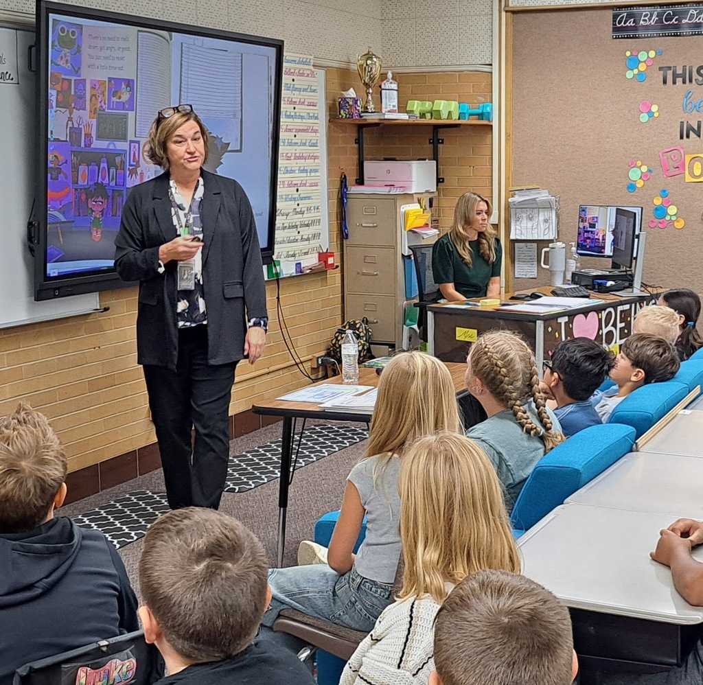 "Educators presenting to elementary school students in various classroom settings, with some using interactive displays."