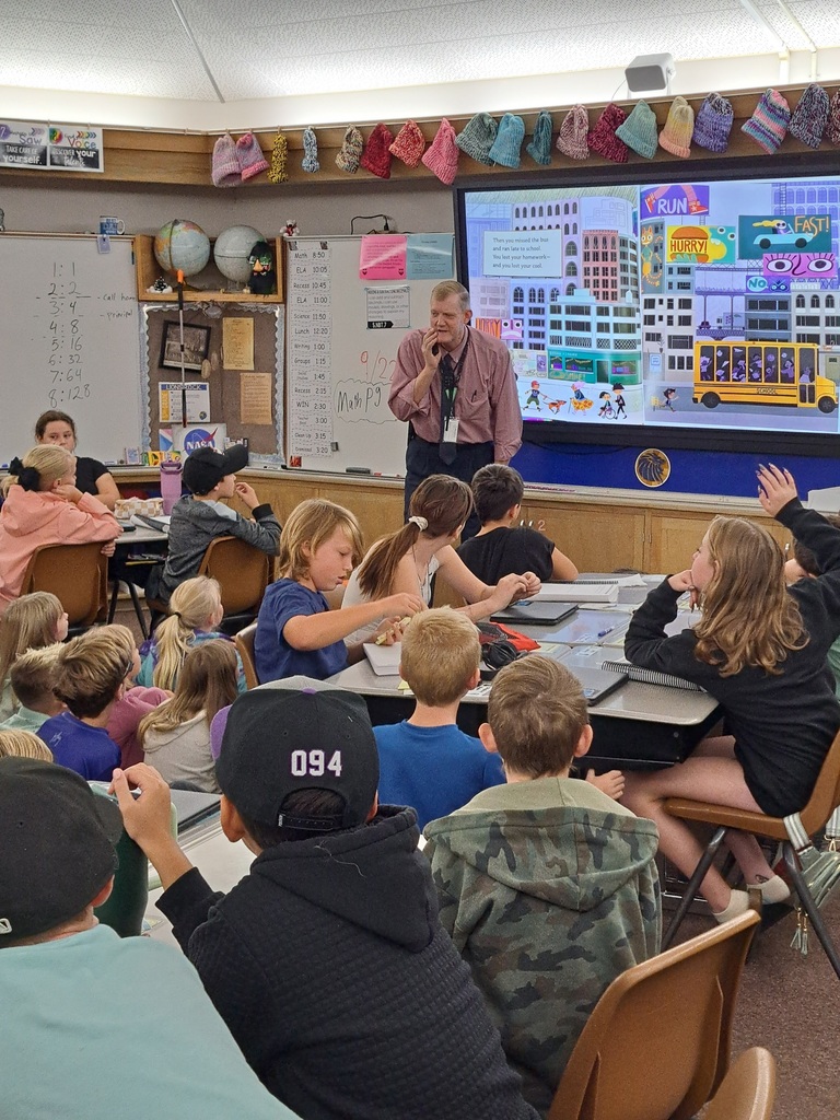 "Educators presenting to elementary school students in various classroom settings, with some using interactive displays."