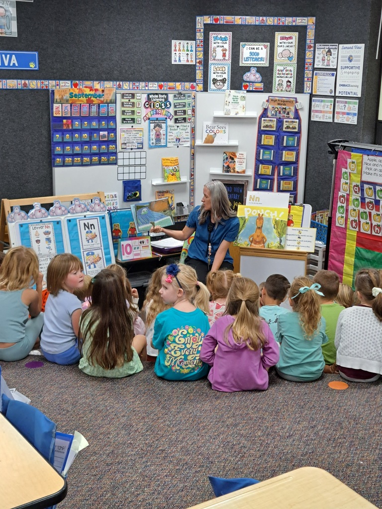 Principal reading a book to kindergarteners in a kiva. 