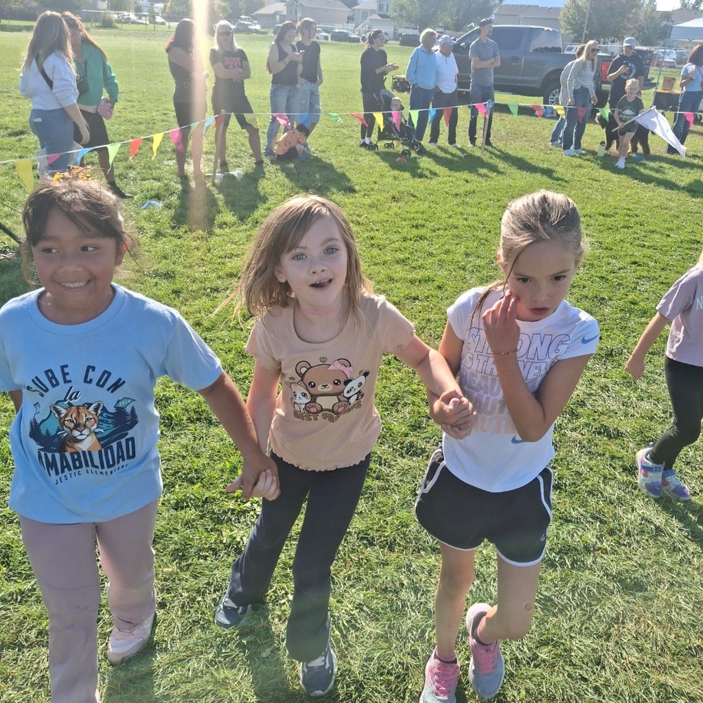 3 girls holding hands at the fun run