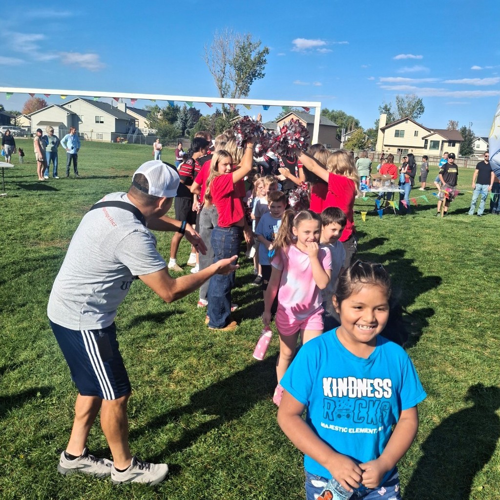 Kids running through a human arch at the fun run
