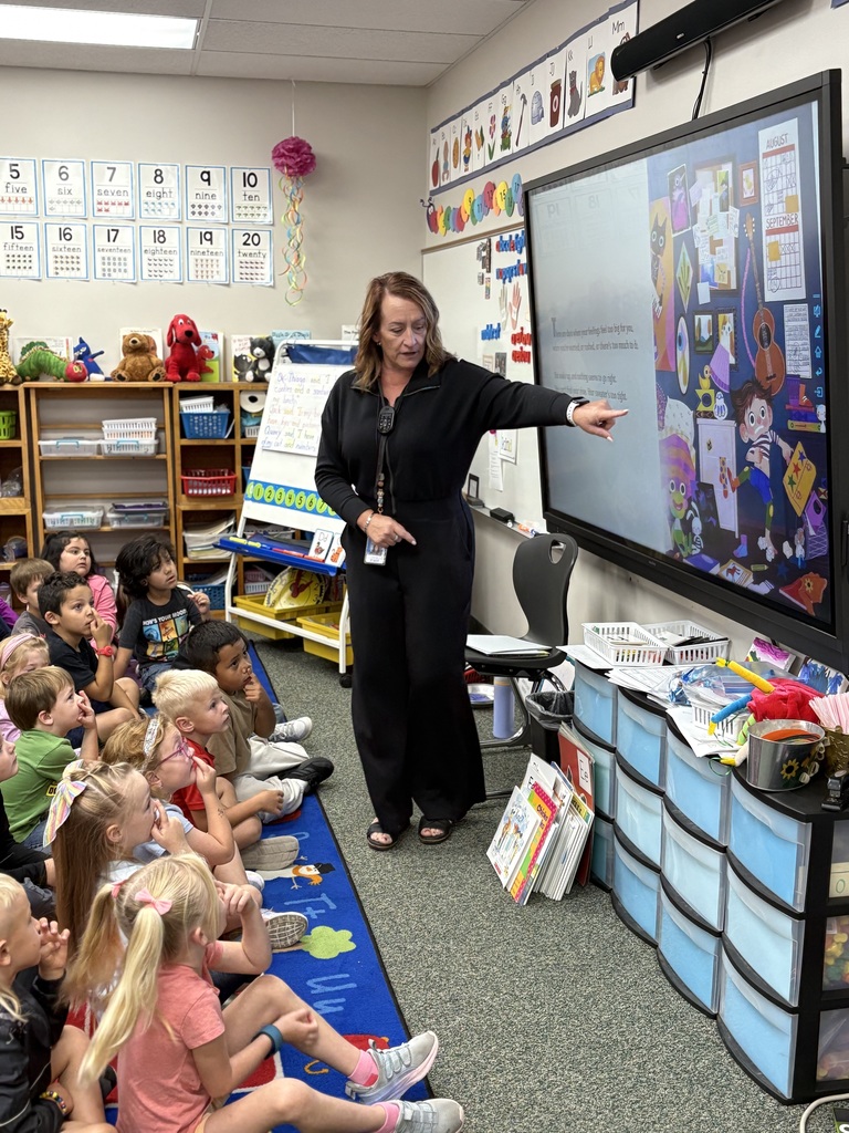 Principal is sharing story with a group of kindergarten students