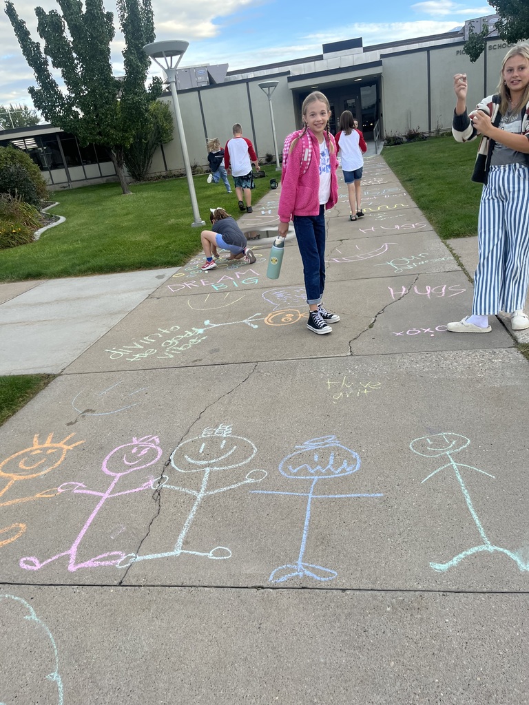 Students smiling with their chalk art and messages