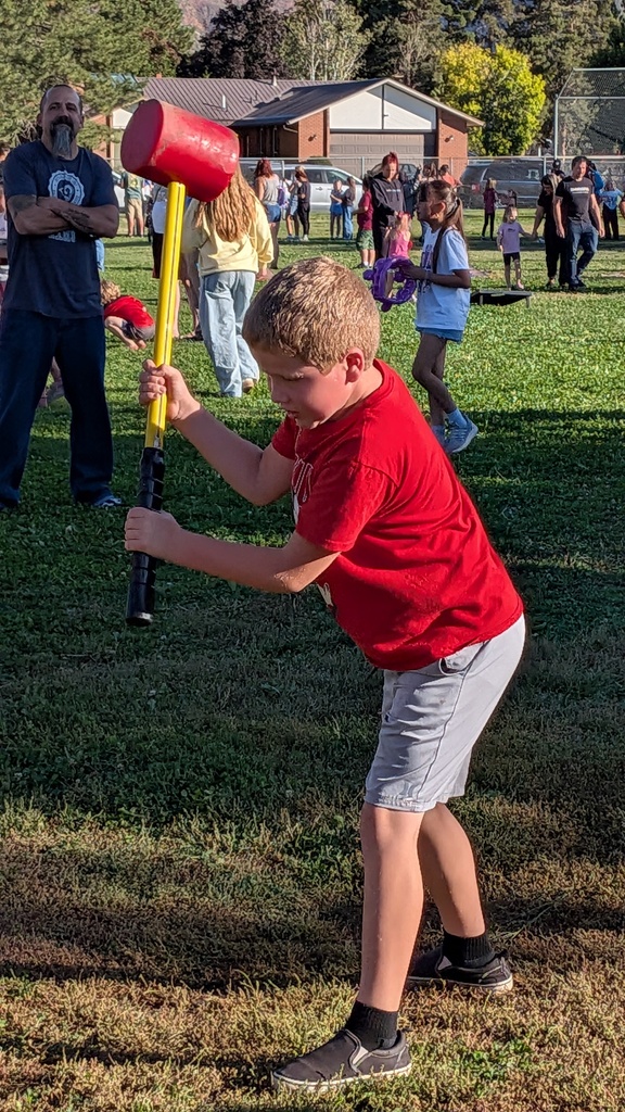a boy at carnival swinging a mallet