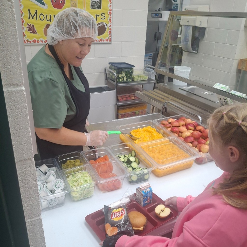 Camisha serving lunch to kids