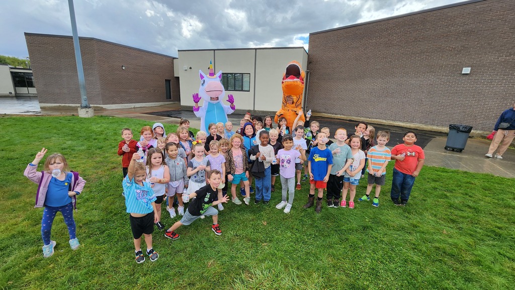 Students celebrating with teachers in blow up costumes for the success of the fun run!