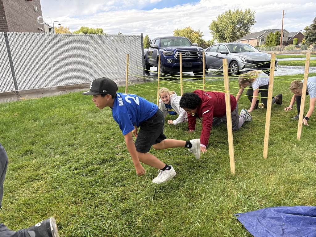Students crawling through an obstacle