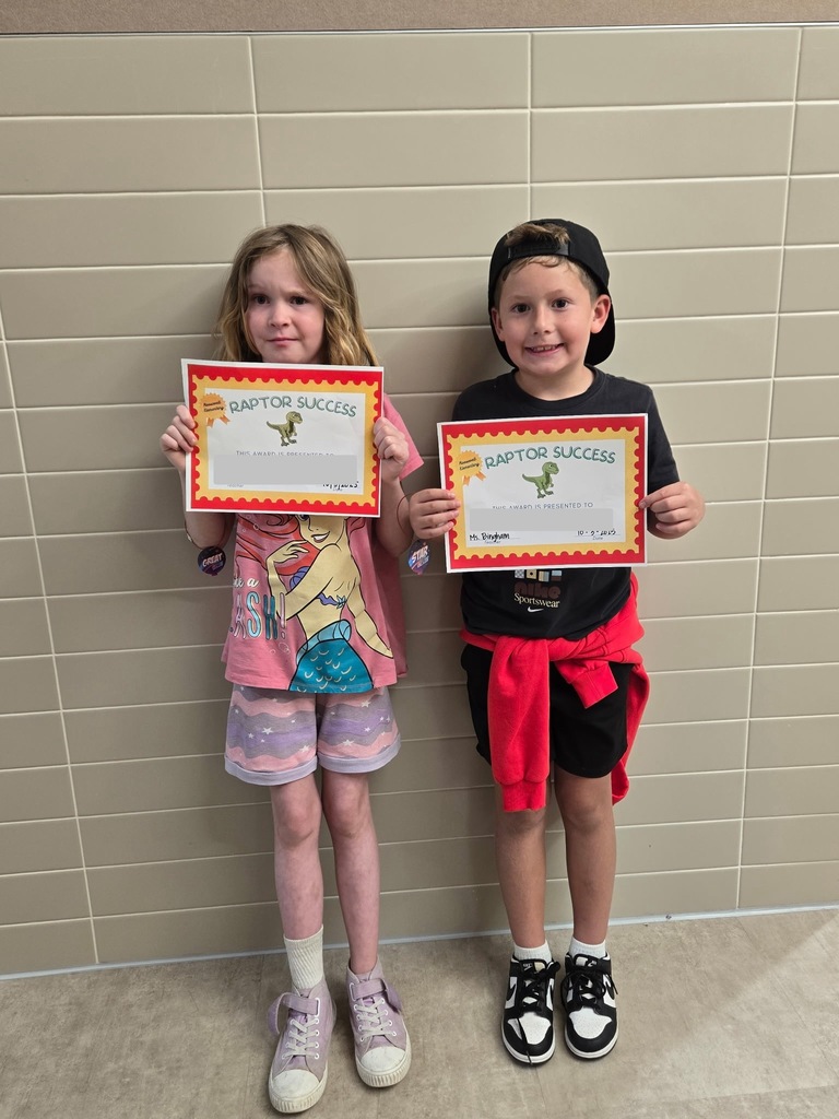 2 students standing with their raptor success awards