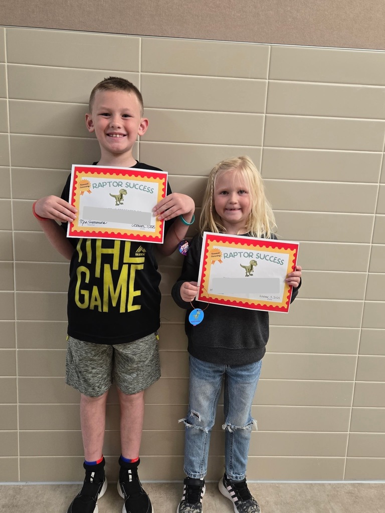 2 students standing with their raptor success awards