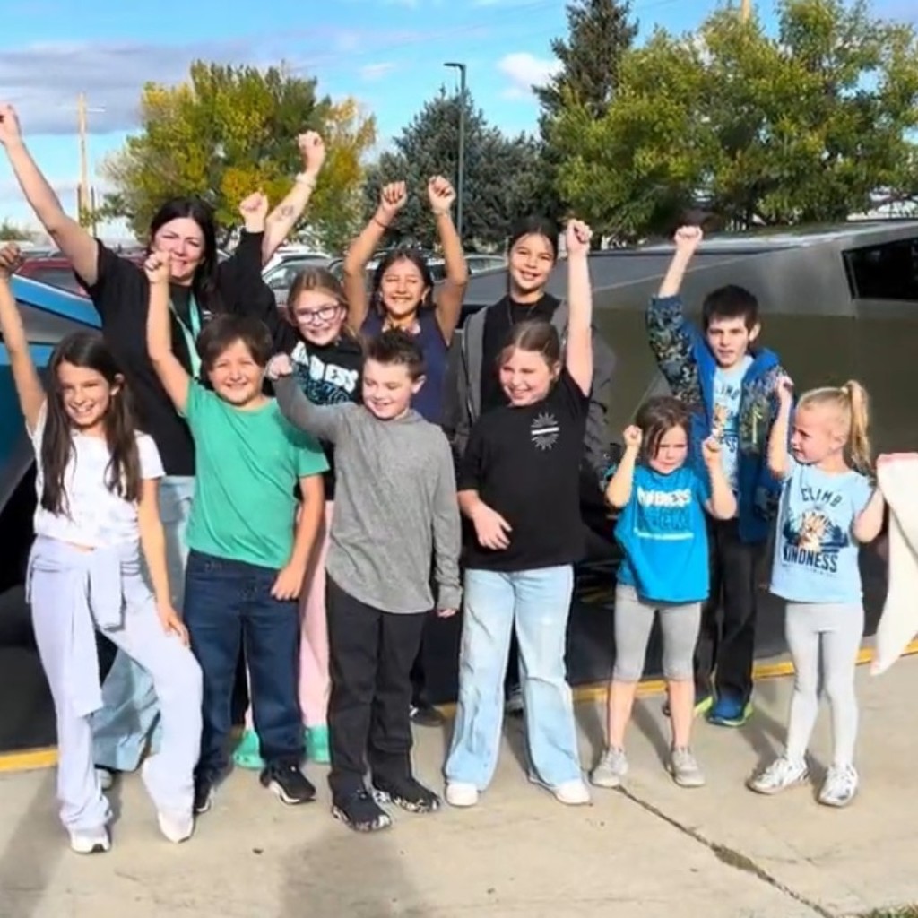 Fundraiser winners in front of Teslas
