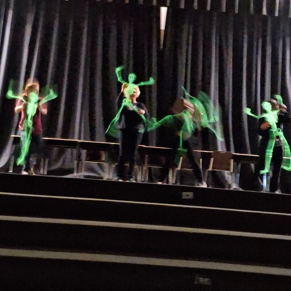 Third Grade teachers holding green glow in the dark skeletons