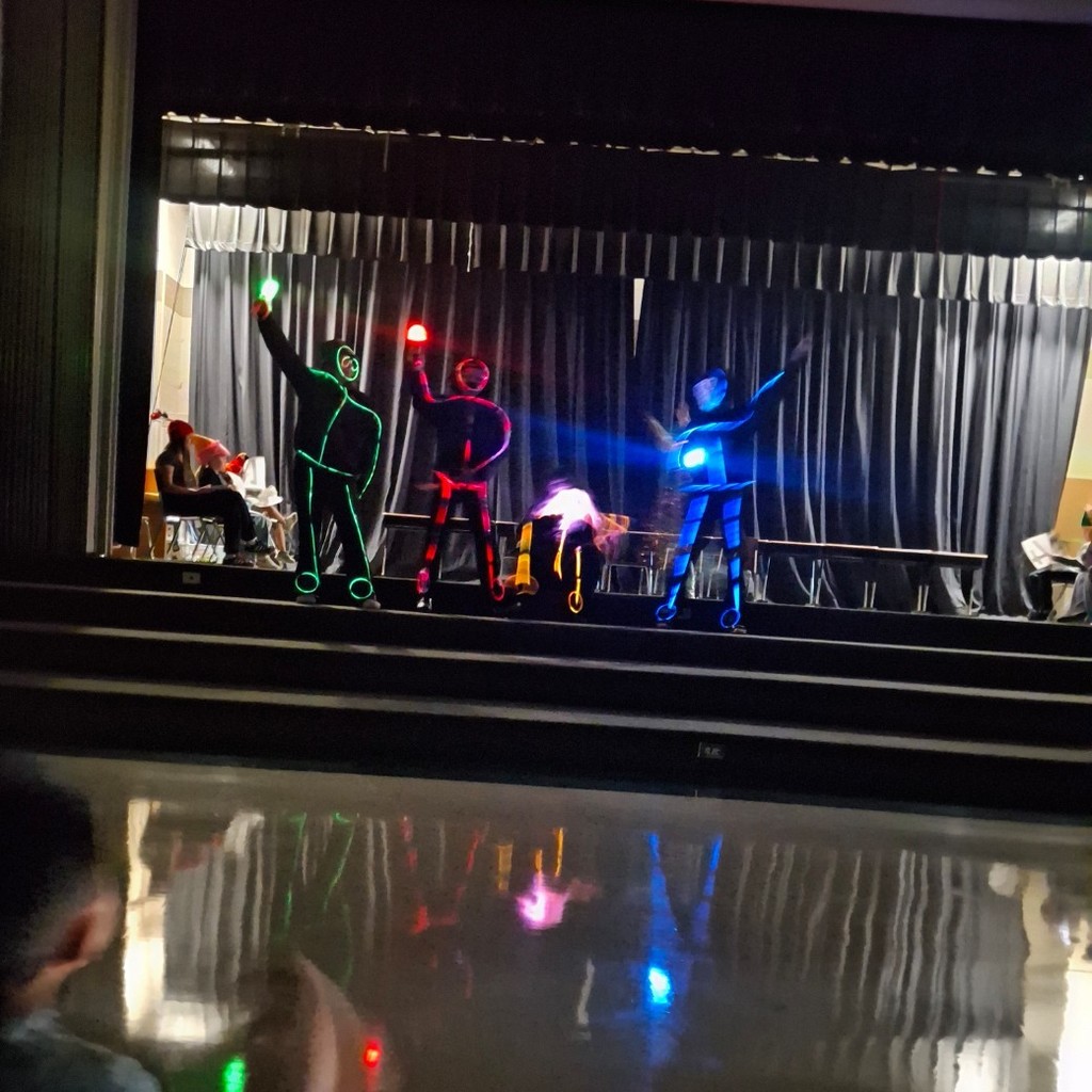 5th grade teachers decorated with glow sticks, dancing.