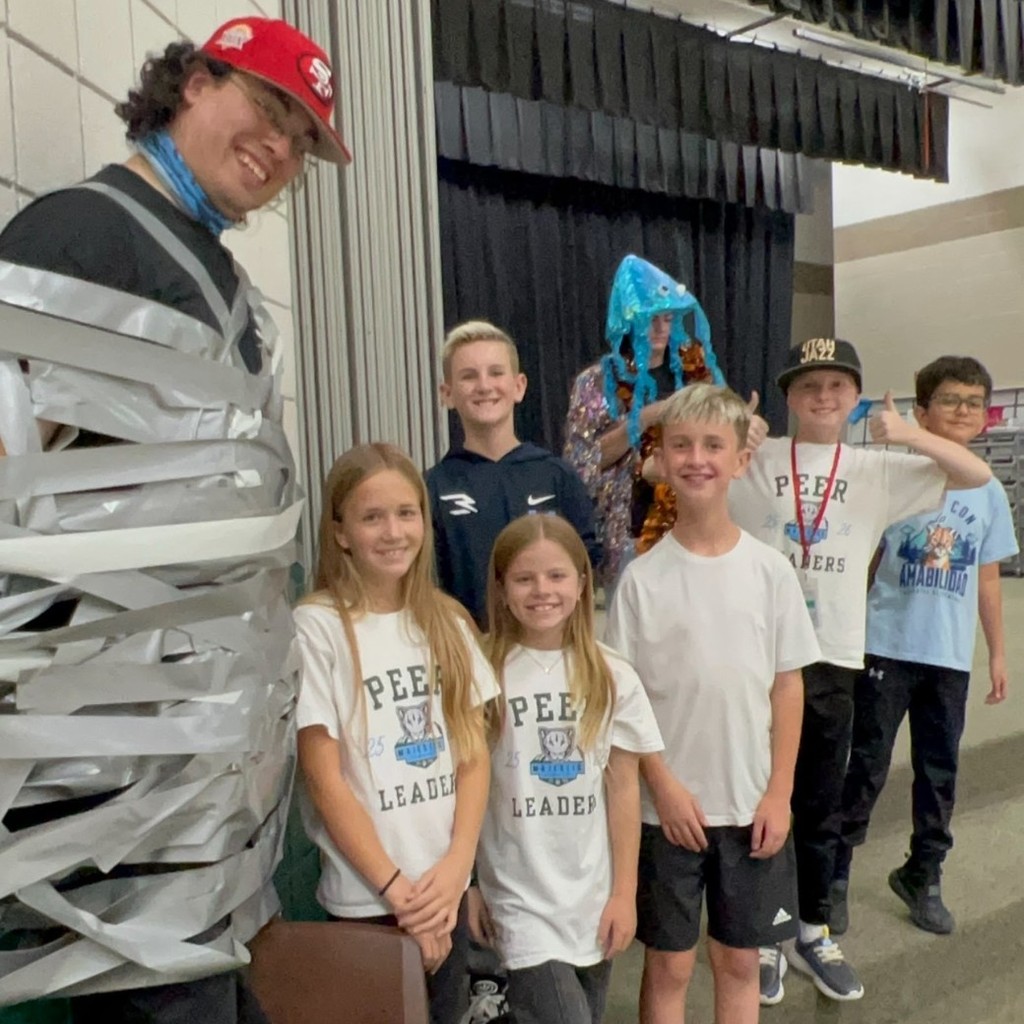 Mr. Z taped to wall with Hope squad Kids standing by.