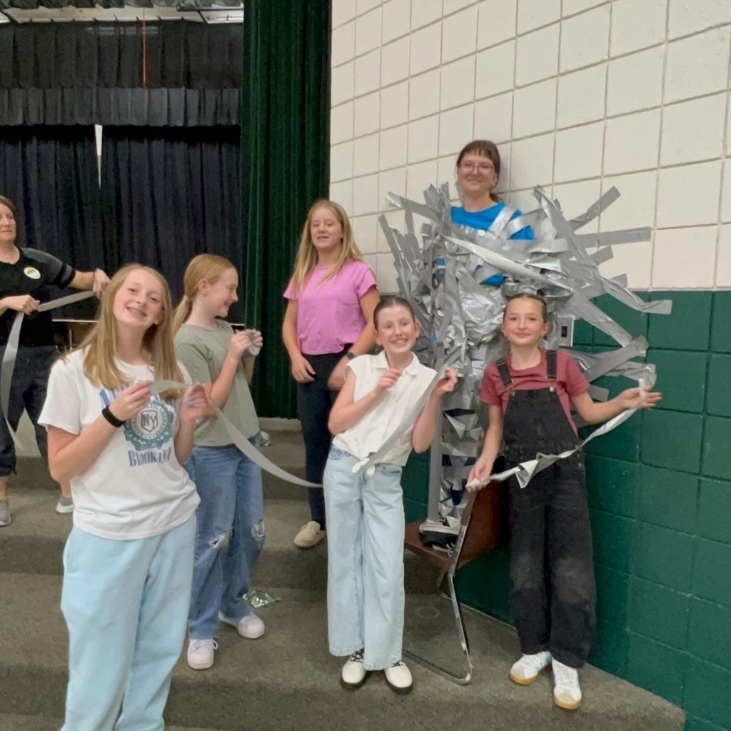 Miss Payton duct taped to wall with Hope Squad Kids standing by
