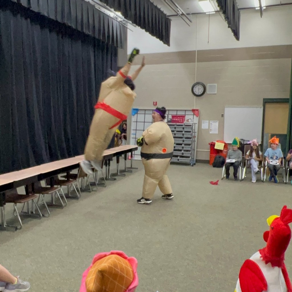 Mr. Pontius and Sr. Findlay dressed like Sumo wrestlers. Mr. Pontius is jumping off a desk to land on Sr. Findlay