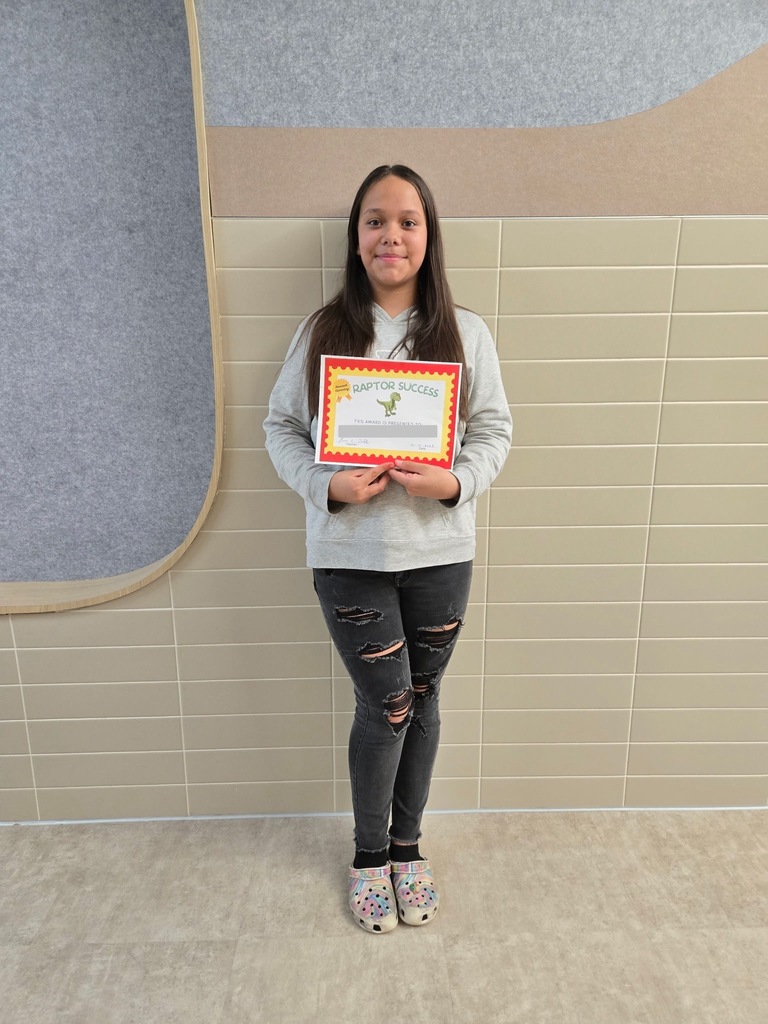 Student standing and holding an award