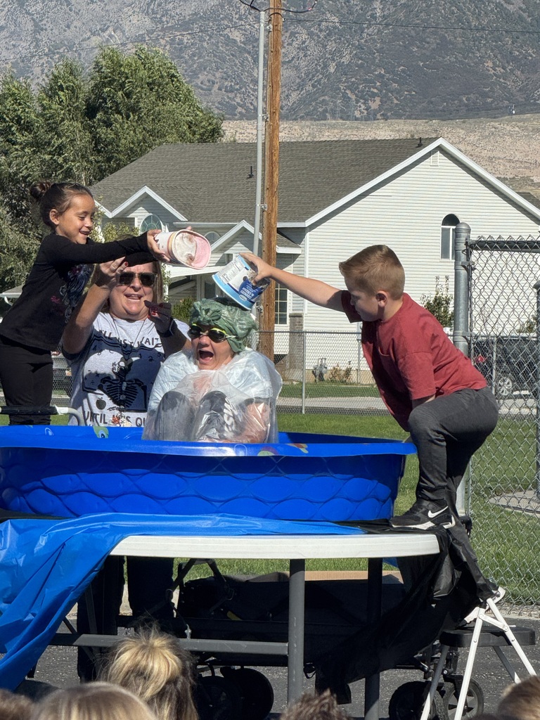 mrs elliott sitting in blue swimming pool getting ice cream, whipped cream, and chocolate fudge dumped on her