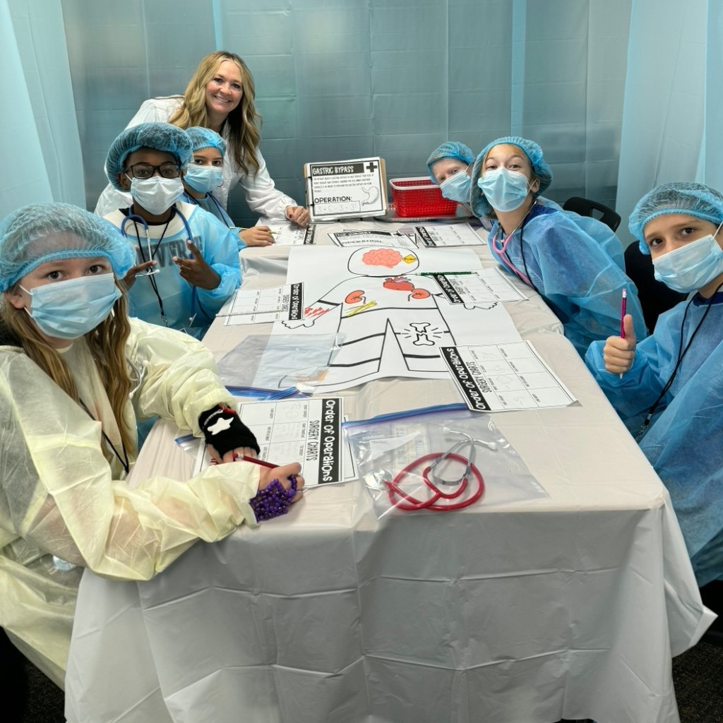Kids dressed like surgeons, working on a project at a table