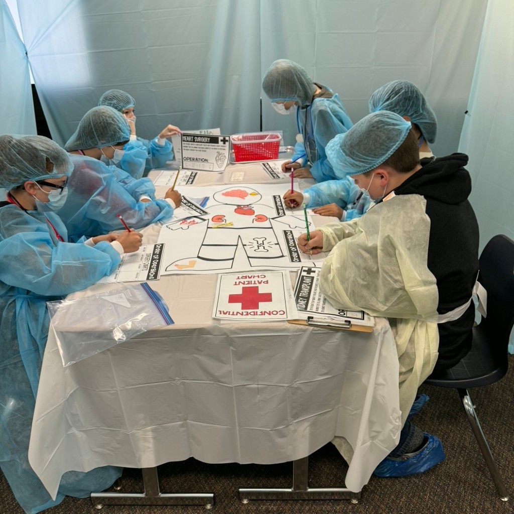 Kids dressed like surgeons working at a table