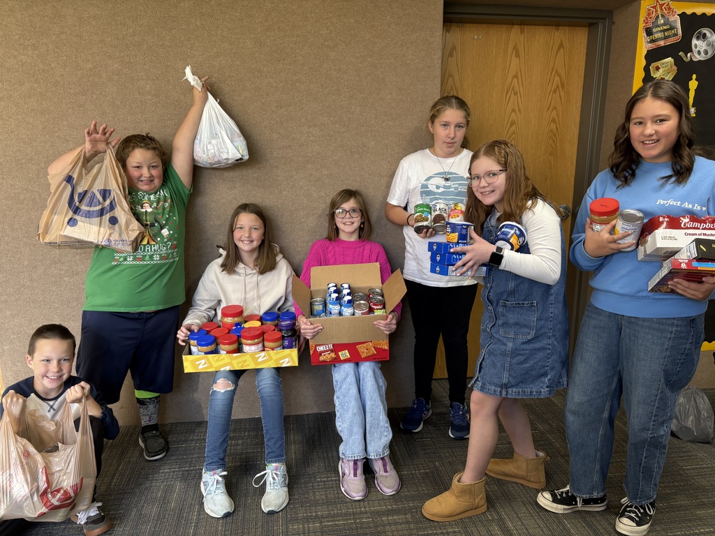 Students posing with food from the food drive